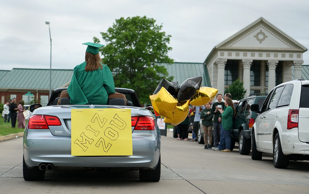 Samantha Mackley sits on the top of her car in the Rock Bridge High School